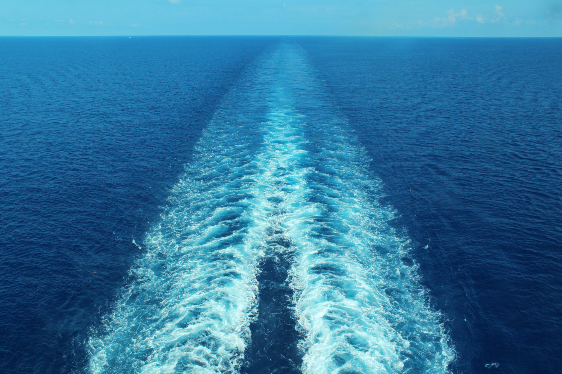 Image of the sea with trails on the surface left by a boat.