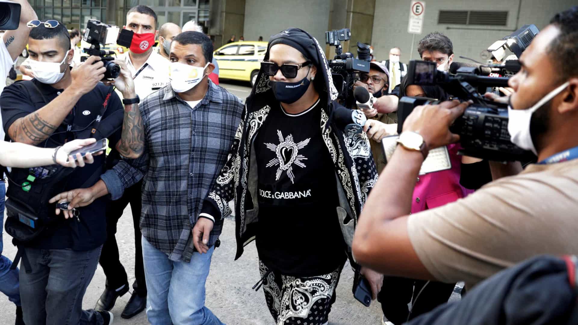 Ronaldinho e irmão desembarcam no Rio e recebem apoio de fãs