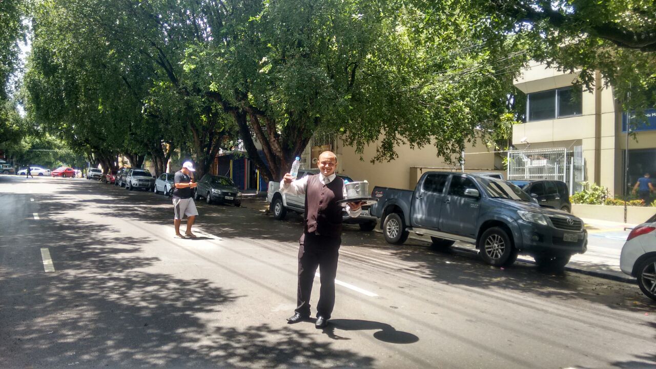 Para fugir do desemprego, ambulante vende água na rua vestido em traje a rigor