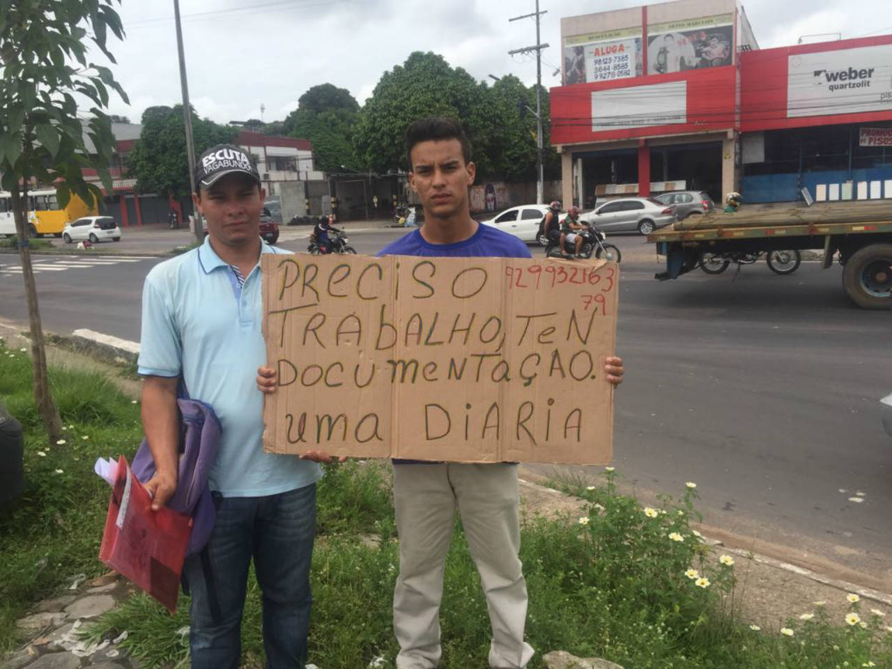 Irmãos venezuelanos exibem placa na rua pedindo emprego em Manaus