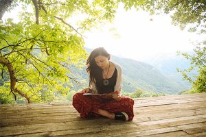 girl reading with mountains behind her