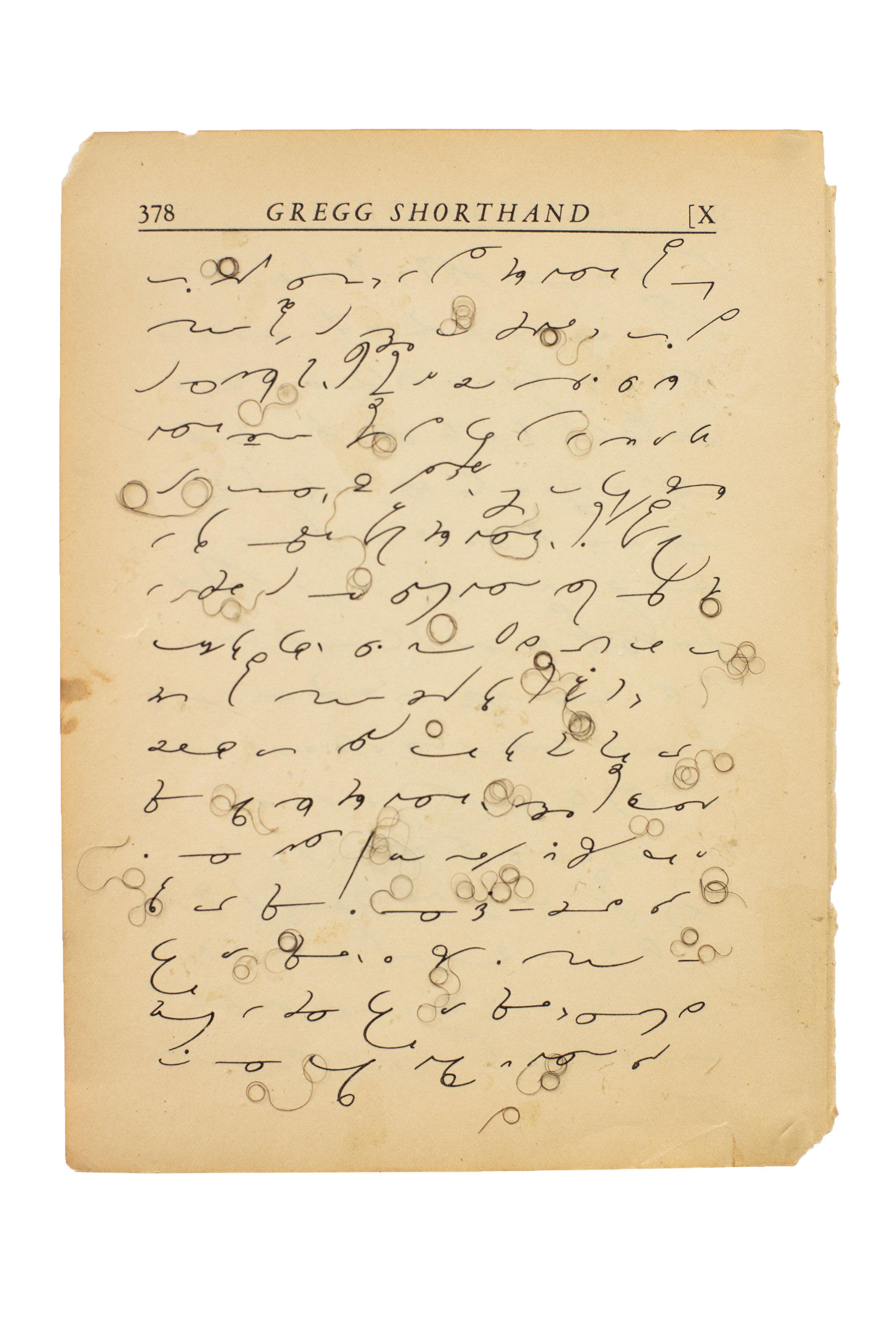 An aged sheet from Gregg Shorthand with curly black hair swirling throughout the shorthand.