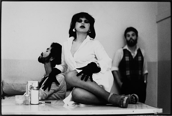 Black and white image of three figures posing at a table