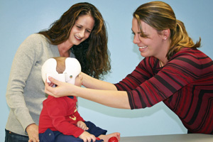 Image of CT Tech fitting Doc Band on baby's head.