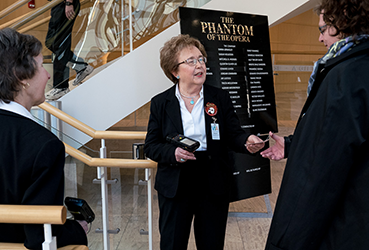 Volunteer greeting audience members and scanning tickets