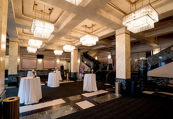 Bistro tables set up for a reception in the lobby of the Victoria Theatre.