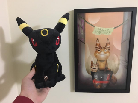 Umbreon plush next to artwork of Loth-cats