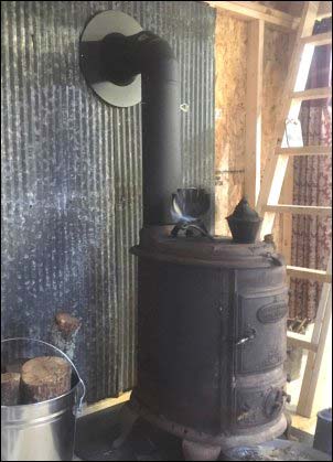 Antique family heirloom wood stove in place in the new portable building cabin