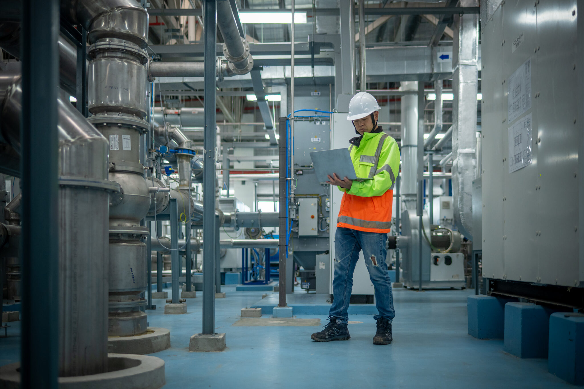 Engineers or technicians working extensive metal piping, HVAC systems, industrial equipment suggesting a controlled, well-maintained environment concept.