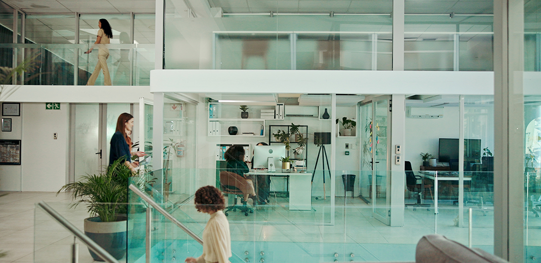 Modern Building, Walking And Business People In Office For Coworking, Productivity And Synergy. Professional, Corporate And Workers In Glass Workplace For Meeting, Working And Busy For Career Or Job