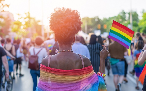 black woman holding Pride flag in a crowd