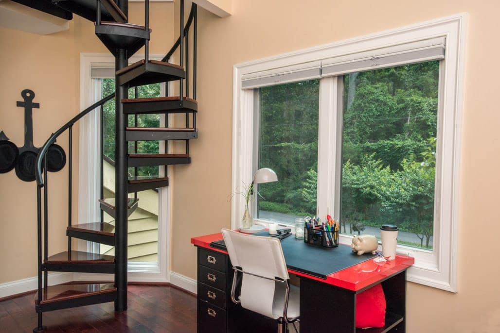 open frame steel spiral stair with dark wood