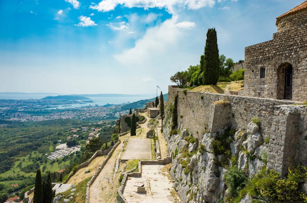 Fortress of Klis outside city of Split in Dalmatia Croatia. Beautiful old ruins and Buildings on high mountain top over the Adriatic Sea. Nice architecture of stone constructions. Ancient Royal Castle