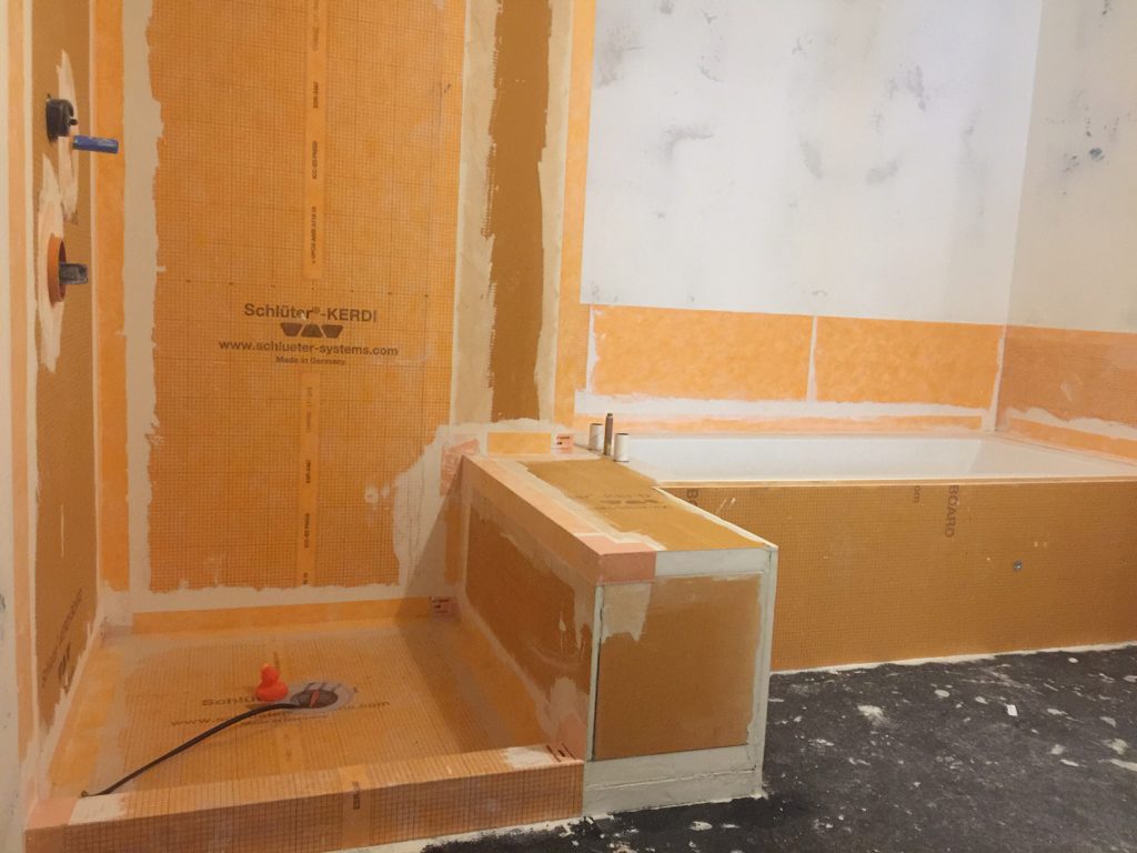 Waterproofing membrane was wrapped from the wall to the tub deck to create a waterproof splash zone for the tub area.