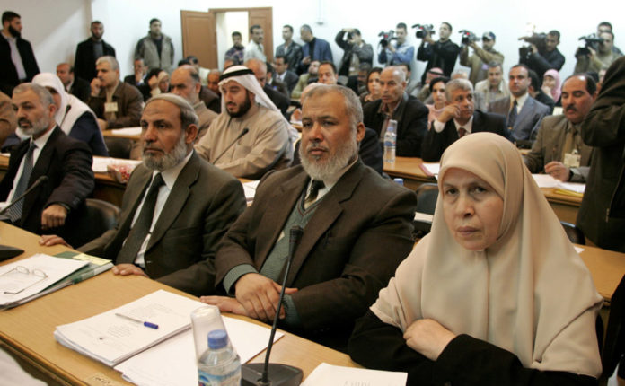 Palestinian lawmakers Mariam Farhatis (R) and Marwan Abu Rass (2nd-R) sit next to top Hamas official..