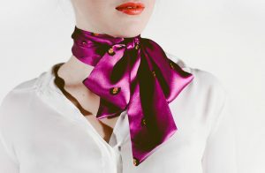 Close up of Andie & Erin's Queen of Media purple silk bow tie inspired by Oprah and work as a pussybow