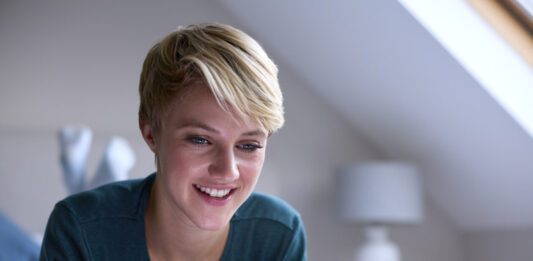 Codecademy Sale – Get 60% Off in 2025 Happy woman using a Codecademy deal on her laptop