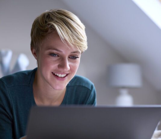 Codecademy Sale – Get 60% Off in 2025 Happy woman using a Codecademy deal on her laptop