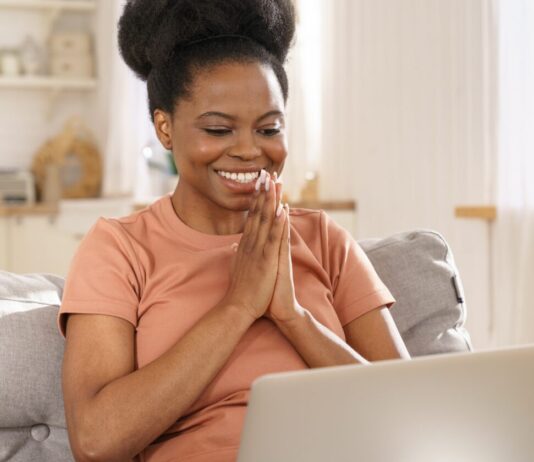 Creative Market Black Friday and Cyber Week Sale Smiling woman looking at Creative Market Black Friday Sale on her laptop