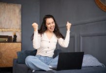 Creative Fabrica Cyber Week Deals 2024 Excited woman looking at laptop and happy about the Creative Fabrica Black Friday sale