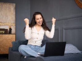 Creative Fabrica Cyber Week Deals 2024 Excited woman looking at laptop and happy about the Creative Fabrica Black Friday sale