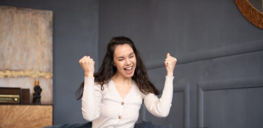 Creative Fabrica Cyber Week Deals 2024 Excited woman looking at laptop and happy about the Creative Fabrica Black Friday sale