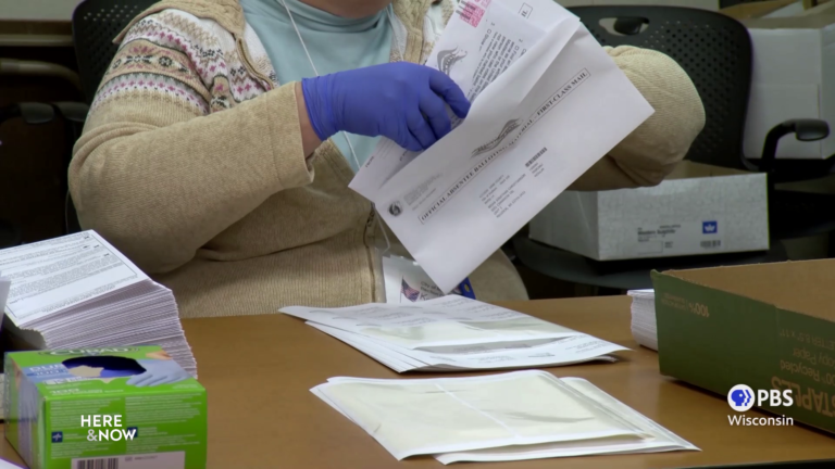 A city official prepares an absentee ballot in Madison. A city official prepares an absentee ballot in Madison.