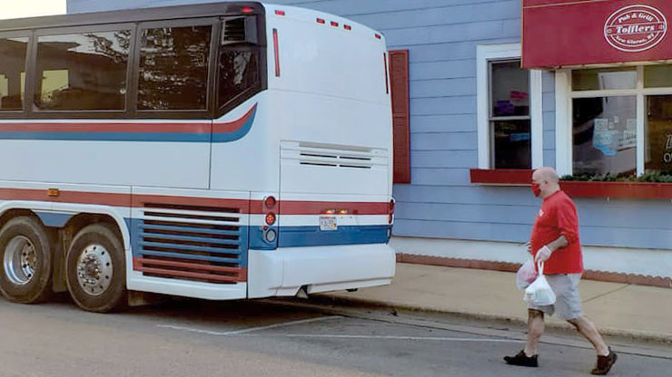 Man carrying take out food to a tour bus