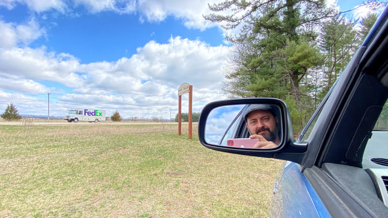 Reflection of man in car's side mirror holding cell phone Reflection of man in car's side mirror holding cell phone