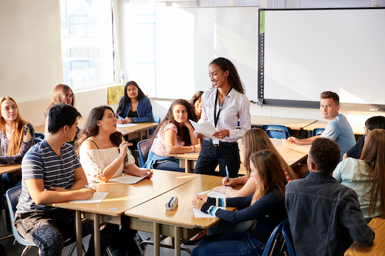 Teacher helping students. Is teaching recession proof?