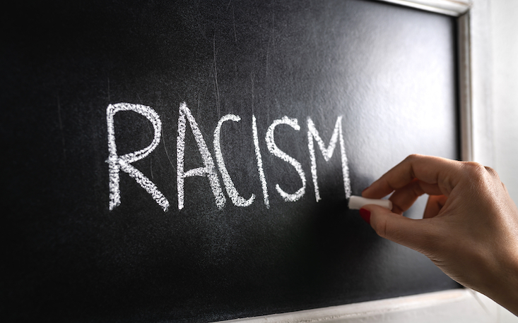 Photo of chalkboard with text "racism". Anti-racism in the classroom.