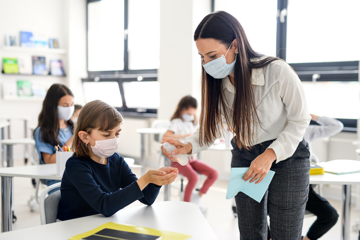 Photo of teacher with students in classroom.