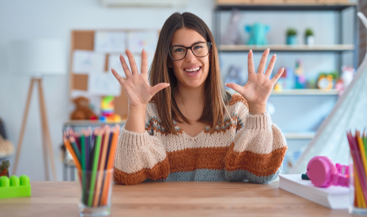 woman sitting at a desk holding 10 fingers up